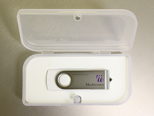 A White SWM Style Custom USB Drive Inside An Open Clear Plastic Case